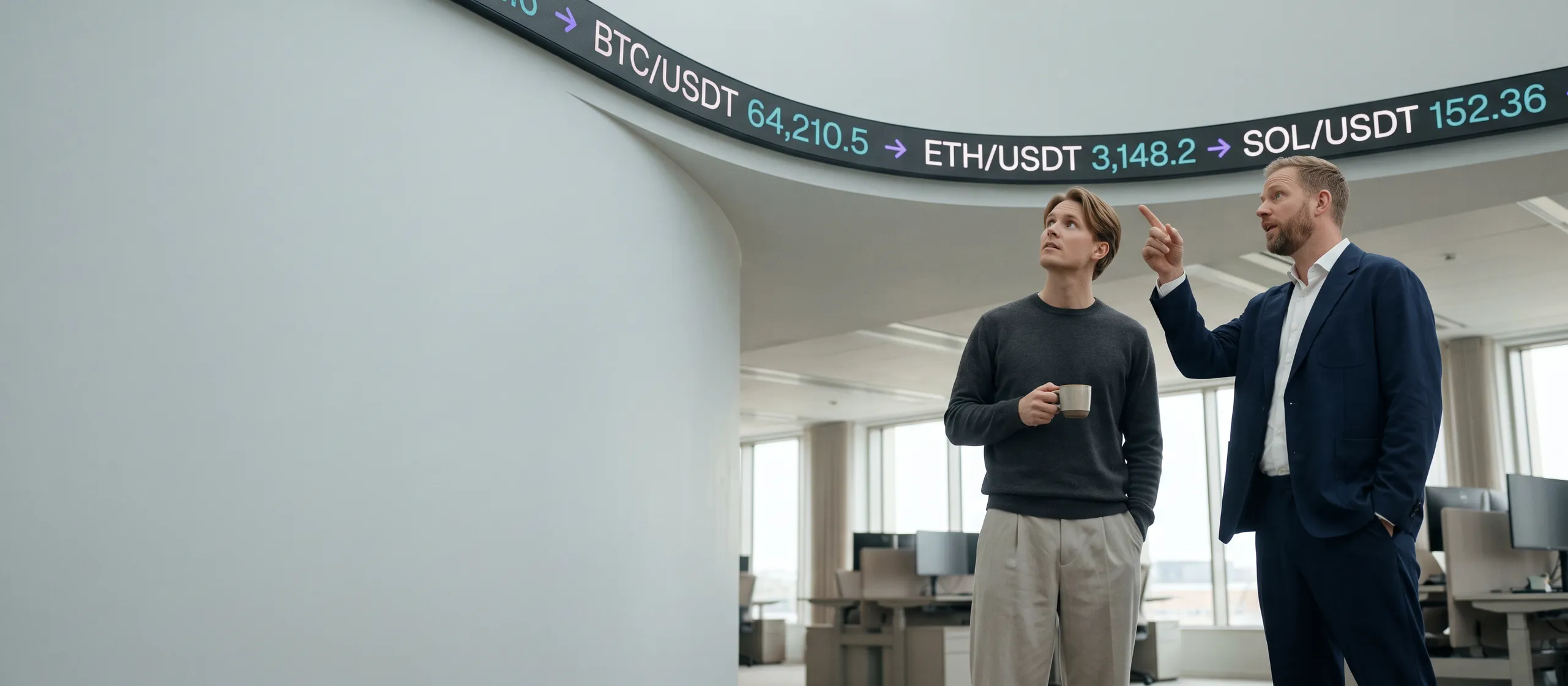 Two colleagues talking under a trading-floor ticker showing crypto prices